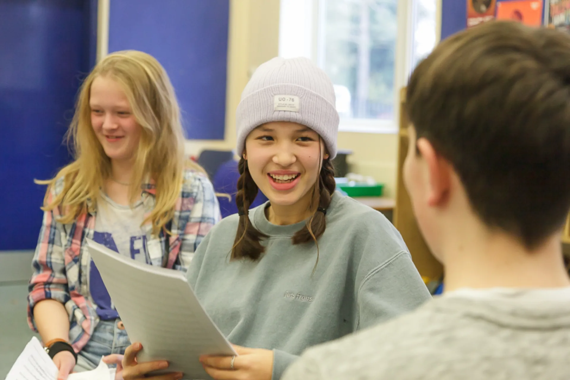 Teenagers holding sheet music smiling